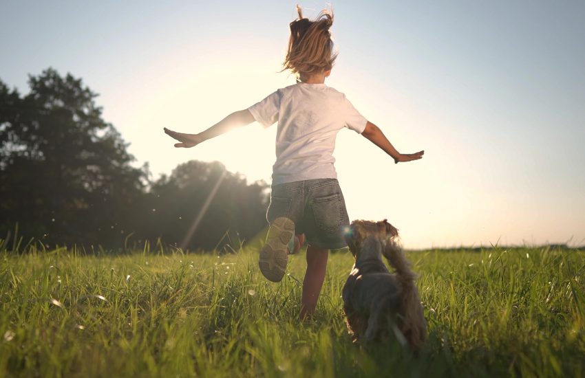 niña y perro en el cesped