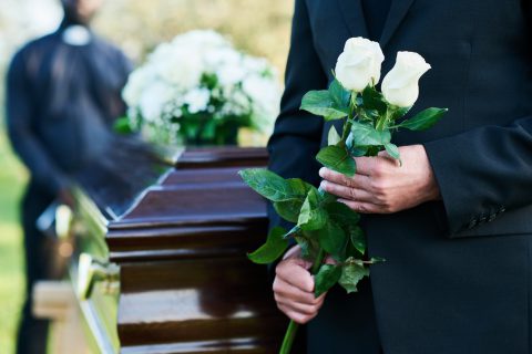 señor en un funeral sujetando unas flores