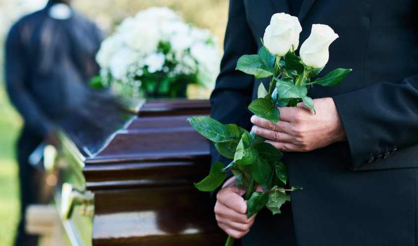 señor en un funeral sujetando unas flores