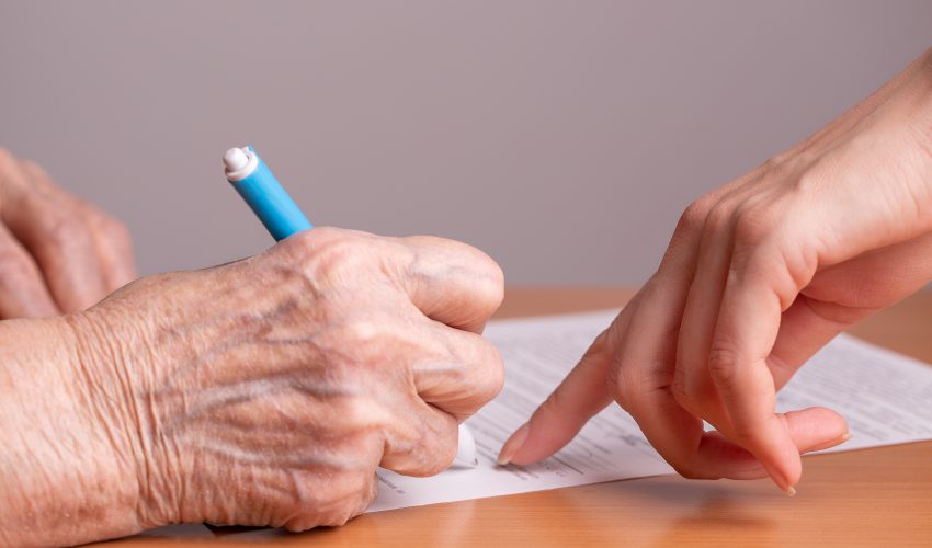 anciana firmando un documento