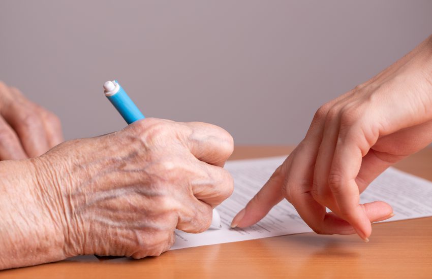 anciana firmando un documento