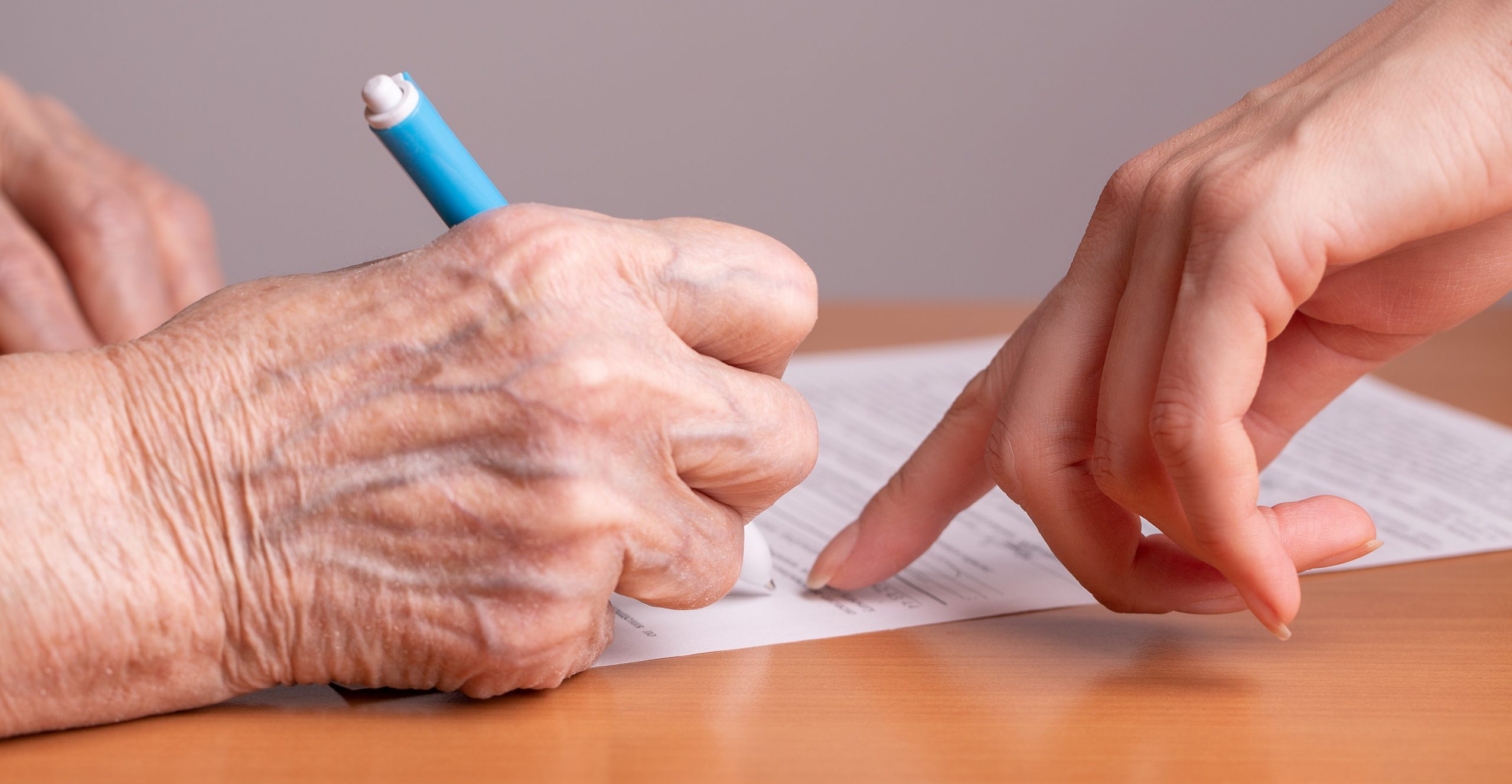 anciana firmando un documento