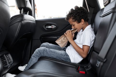niño vomitando en el coche