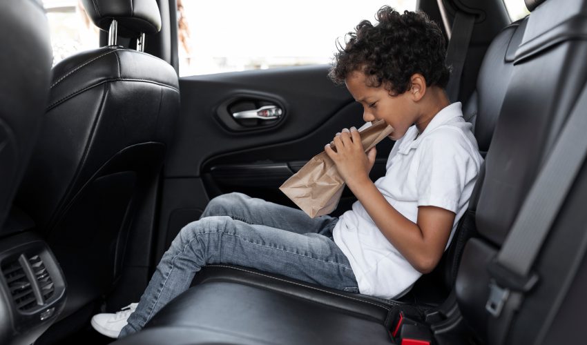 niño vomitando en el coche