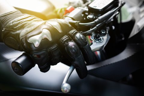persona agarrando el manillar de una moto