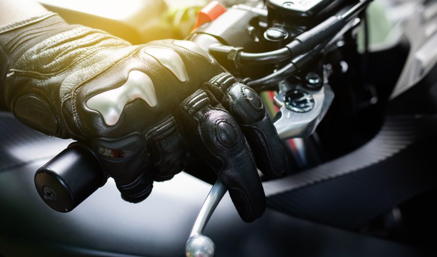 persona agarrando el manillar de una moto