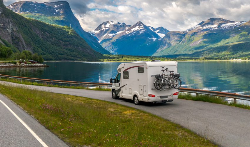 autocaravana en la carretera frente a un lago