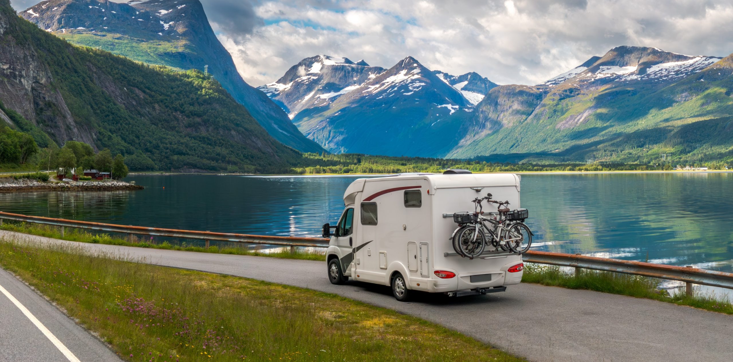 autocaravana en la carretera frente a un lago