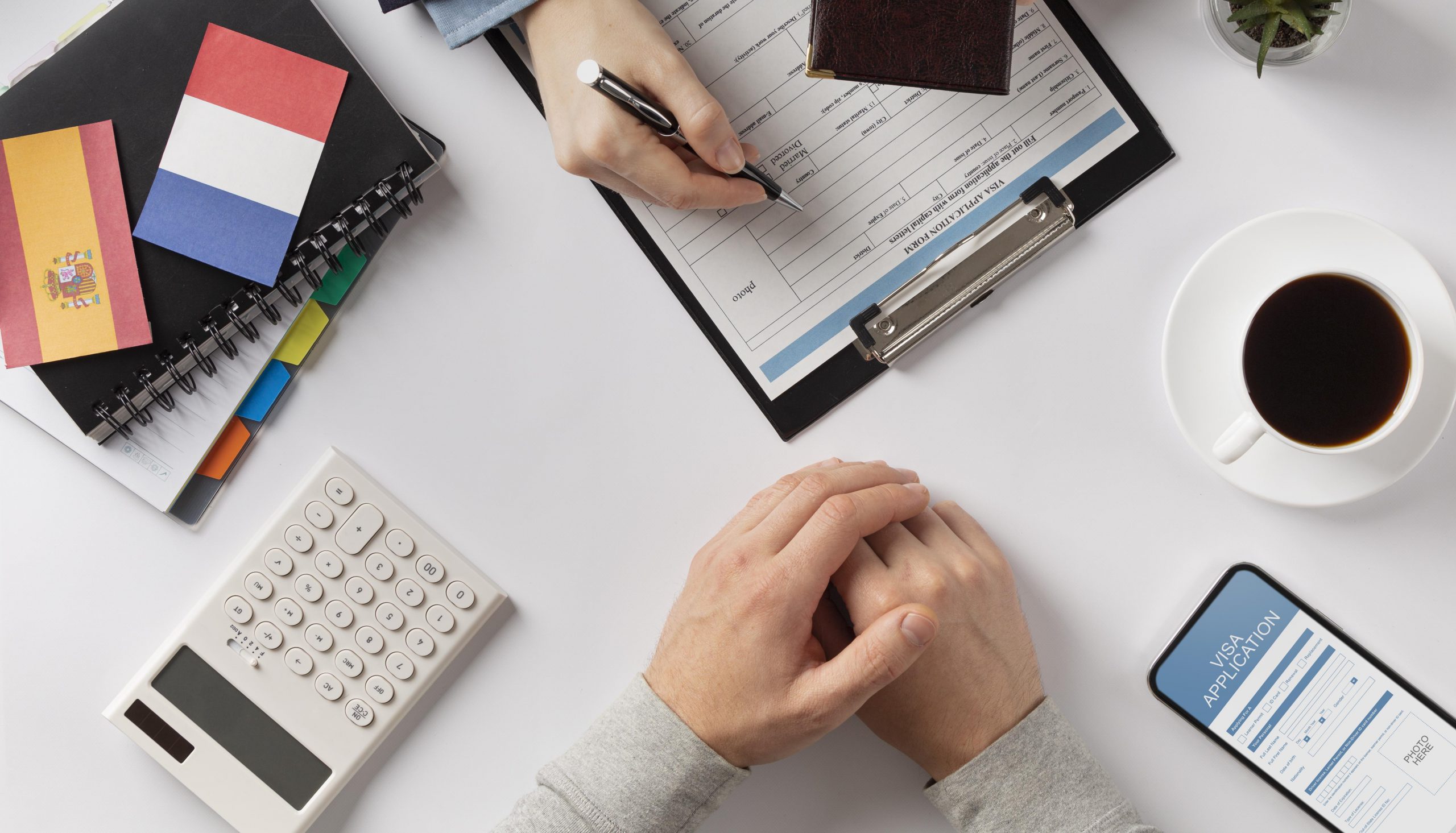 dos personas firmando un documento de solicitud de visa
